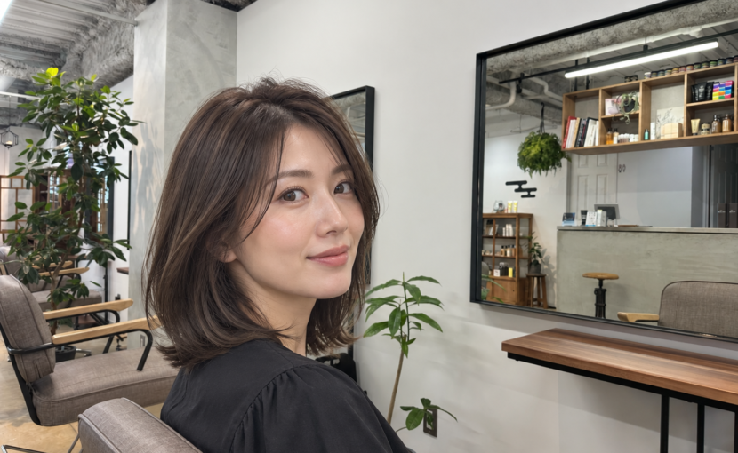 自然光でやわらかく見える暗めのオリーブグレージュブラウンのミディアムヘア